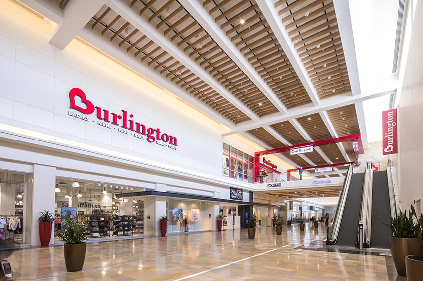 A view inside Bergen Town Center shopping mall featuring various corridors, decorations, stores, and a prominent sign.