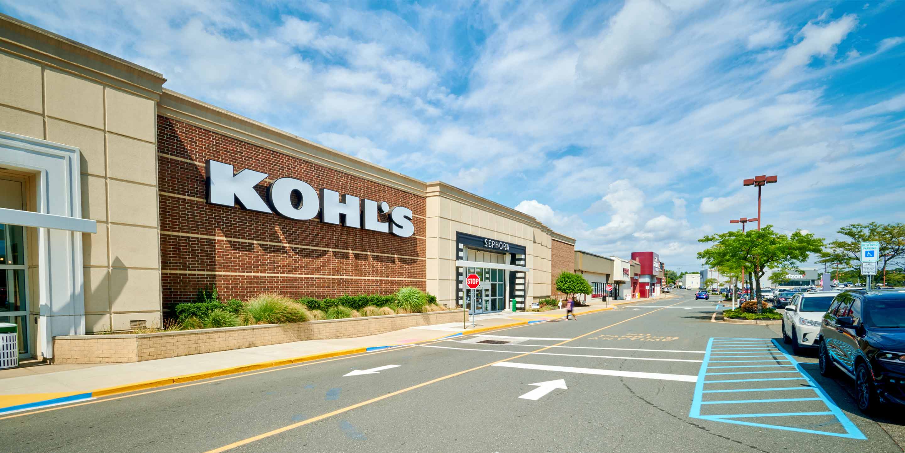 Detailed view of Brunswick Commons shopping center with various stores, colorful banners and busy shoppers.