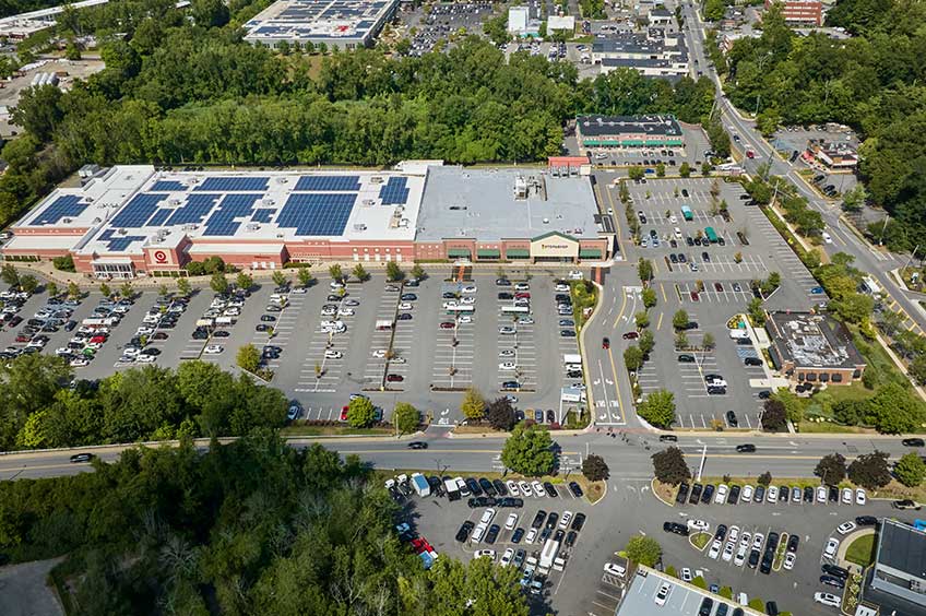 Aerial view of Mount Kisco Commons shopping center and its adjacent parking lot, captured from a high vantage point.