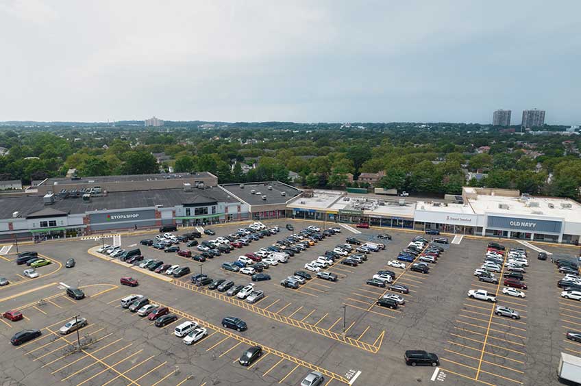 Aerial view of New Hyde Park shopping center and its adjacent parking lot, captured from a high vantage point.