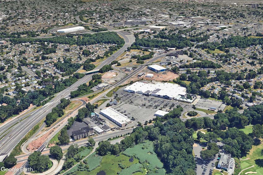 Aerial view of West Branch Commons shopping center and its adjacent parking lot, captured from a high vantage point.